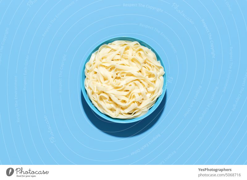 Tagliatelle pasta top view. Cooked noodles in a bowl on a blue background above boiled bright carbs classic color cooked copy space cuisine cut out delicious
