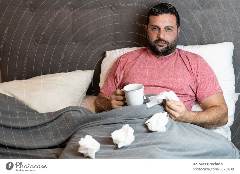 Man with a cold and positive for coronavirus, drinking a tea adult african bed black breathing caucasian clinic clinical corona-virus covid 19 covid-19