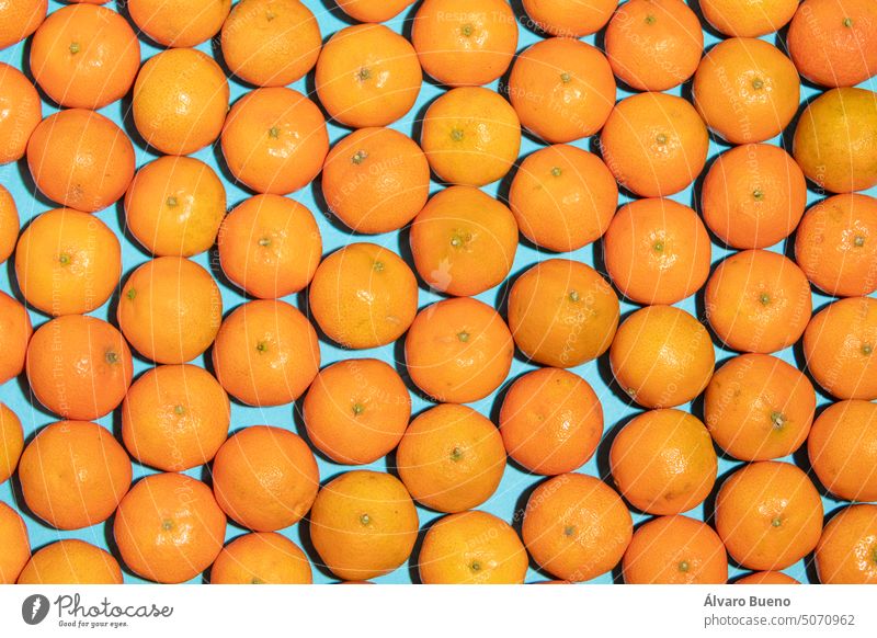 Juicy and healthy mandarins, messy, on a blue background, forming a pop art style texture tangerines fruits vitamin c irregular natural concept imperfection