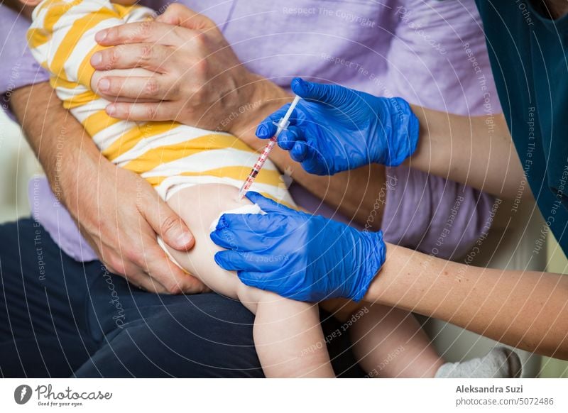 Female nurse with surgical mask and in gloves giving vaccine injection to a baby in clinic. Infant children vaccination. antibiotic arm booster care cry disease