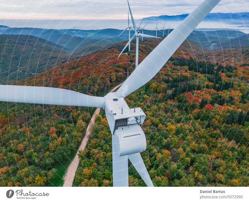 Close-up on the propellers of a wind turbine during a misty morning and sunrise. Green energy. Wind turbine at morning fog aerial view alternative autumn