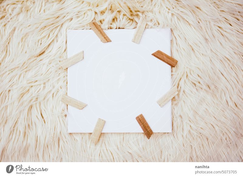 Neutral and natural frame of a canvas surrounded by wooden sticks against a soft carpet mockup neutral background texture flat lay art white brown beige textile