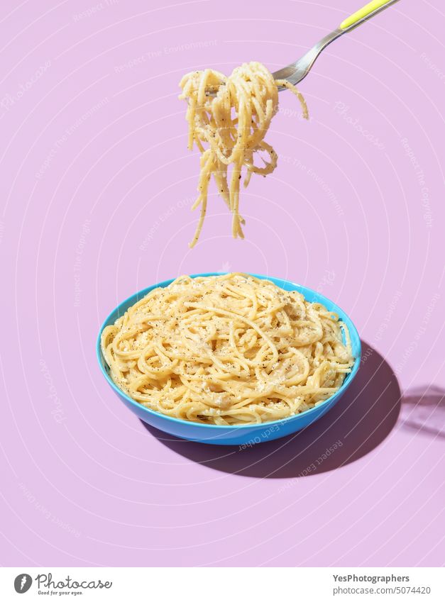 Eating pasta with a fork, minimalist on a purple background bowl bright cacio e pepe carbs cheese color cooked copy space creative cuisine cut out delicious