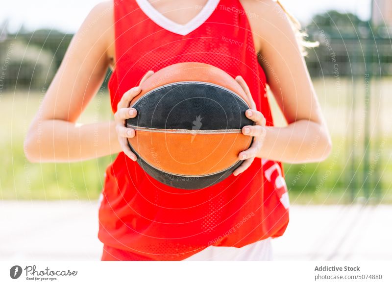 Anonymous female basketball player with ball on sports ground sportswoman streetball unrecognizable crop view faceless goal game summer hobby practice training