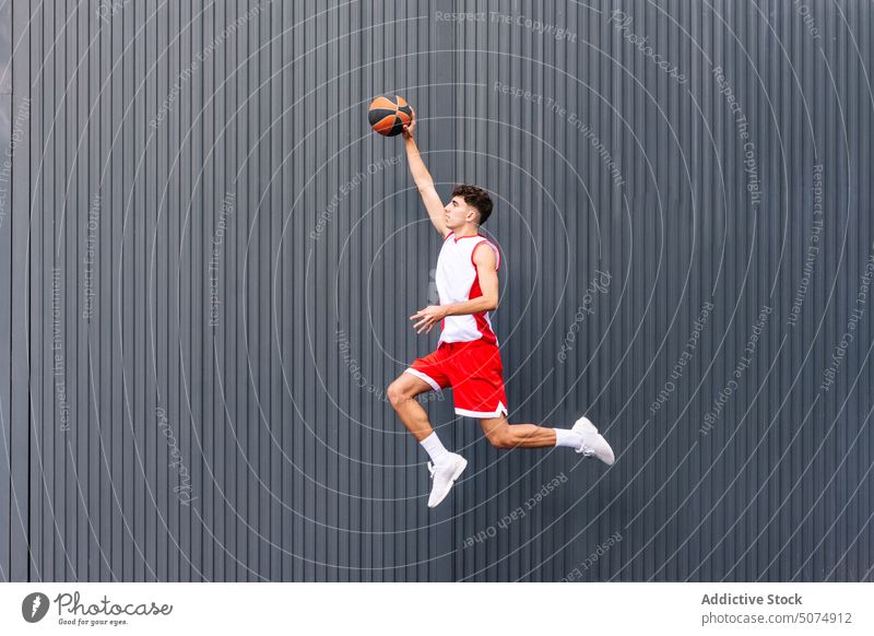 Male basketball player with ball against dark background portrait sportsman jump leap streetball hold sports ground goal game acrobatics male hobby practice