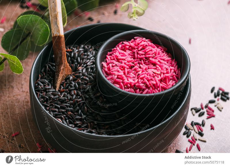 Assorted rice in bowls near eucalyptus twigs assorted natural ingredient table fresh organic vegetarian nutrition composition white black pink diet raw