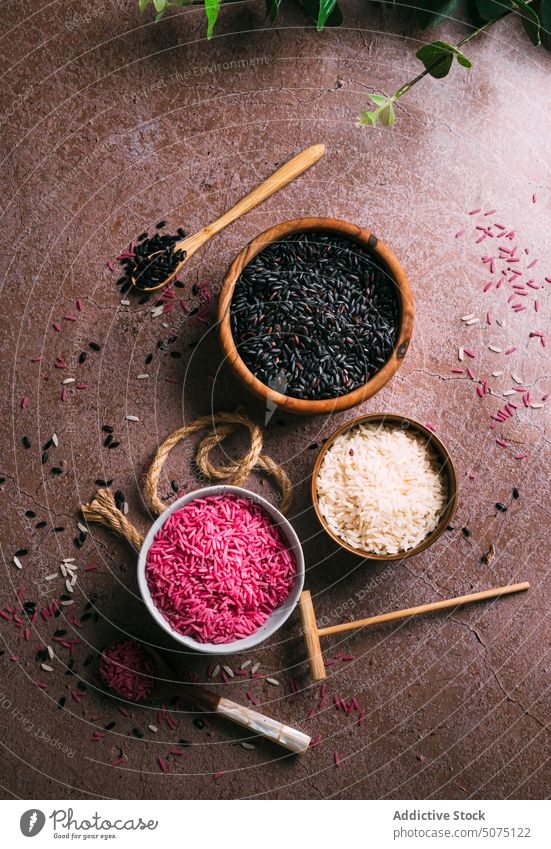 Assorted rice in bowls near eucalyptus twigs assorted natural ingredient table fresh organic vegetarian nutrition composition white black pink diet raw