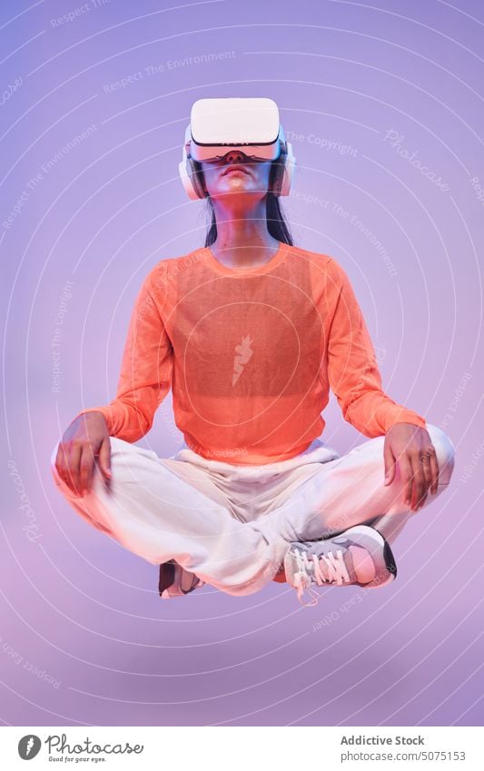 Female meditating in virtual reality woman meditate vr headset calm yoga lotus pose concept levitate futuristic female legs crossed goggles vitality glasses