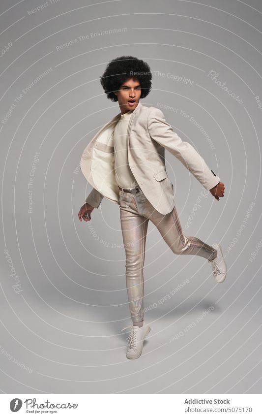 Stylish Hispanic male jumping against gray background man style freedom energy modern model suit dynamic activity young hispanic ethnic personality motion