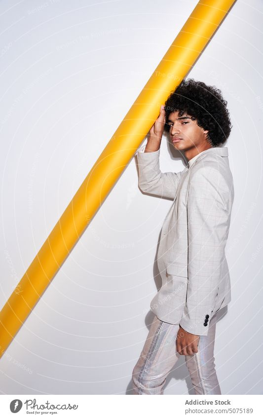 Stylish Hispanic male near yellow pipe man touch style suit model outfit curly hair modern appearance ethnic hispanic young personality individuality guy