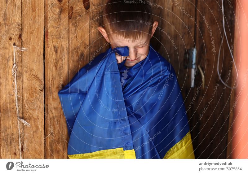 war russia against Ukraine. crying Ukrainian boy with the flag of Ukraine outdoors. Stop war. anti-war protest, cry depression despair, hope human peace, stressed terror warming fear
