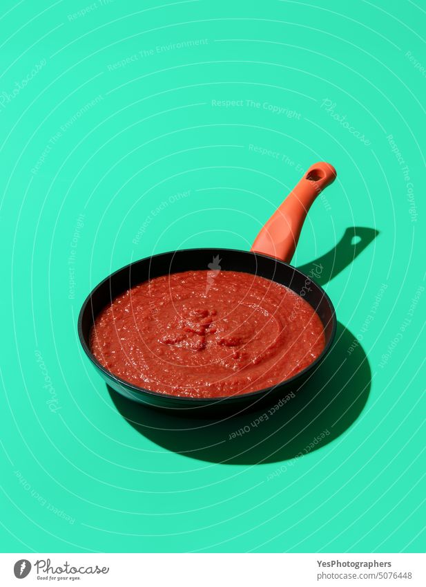Tomato sauce in an iron pan isolated on a green background basil color condiments cooking copy space cuisine cut out delicious design dish flavor food fresh
