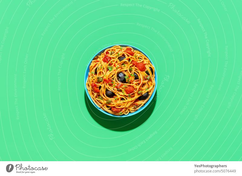 Vegan pasta, spaghetti puttanesca, top view on a green background above bowl bright capers carbs color cooked copy space creative cuisine cut out delicious