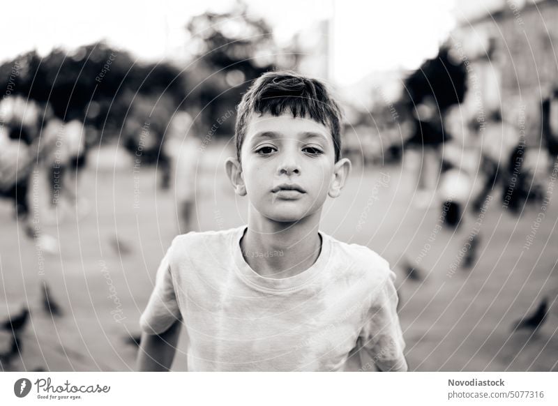 Portrait of a 9 year old boy on the street, black and white image Street natural light Black and white photography alone isolated person one boy only Gesture