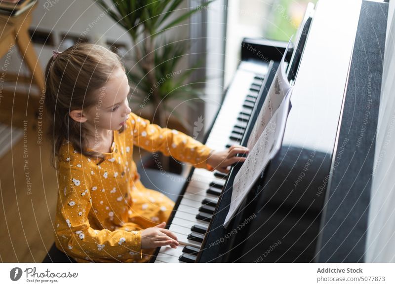 Little blond girl practicing music with the piano child learning person musician pianist childhood education practice instrument classical indoor play hobby