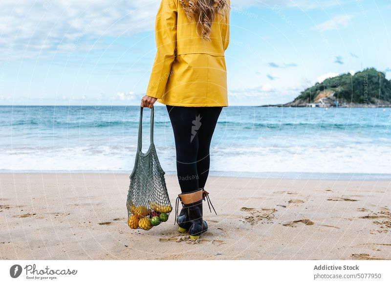 Woman with fruits in bag admiring beach woman wave sea standing sandy water apple organic female coast donostia vacation admire nature spain wet tourist weekend
