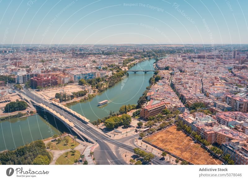 City of Seville with river and bridges under cloudless sky city seville multistory house blue sky andalusia building spain architecture turquoise cityscape