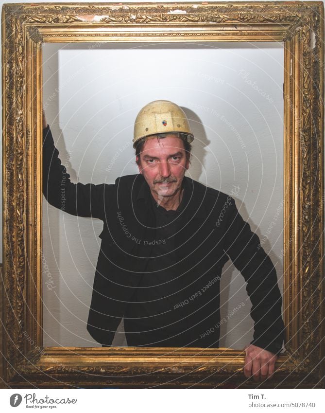 Worker with helmet in golden frame lars Frame Working man Helmet Man Human being Work and employment Colour photo Construction site Craftsperson Industry Tool