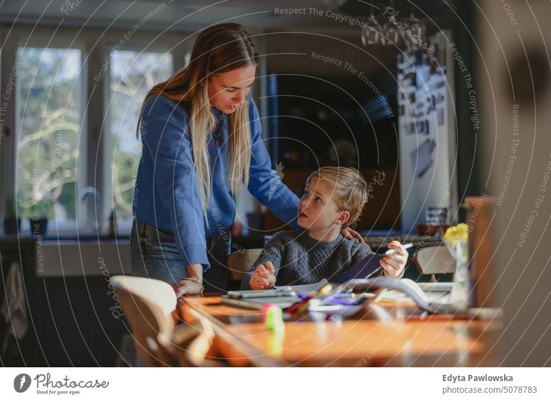 Mother helps son with homework at home real life real people Bonding Family indoors quality time House (Residential Structure) Parenting children enjoyment Day