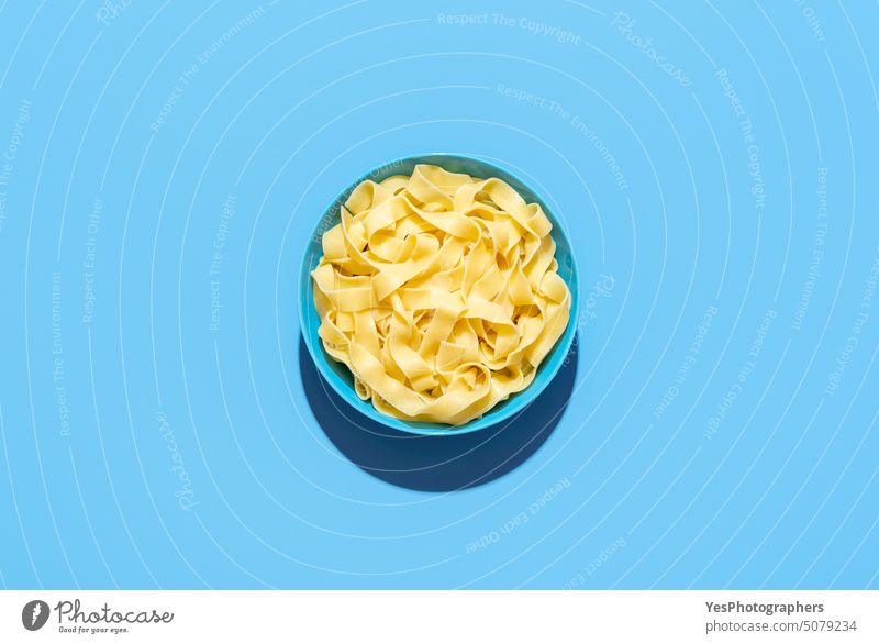 Pappardelle pasta bowl isolated on a blue background above bright carbs color cooked copy space cuisine cut out delicious dinner dish fettuccine flat lay food
