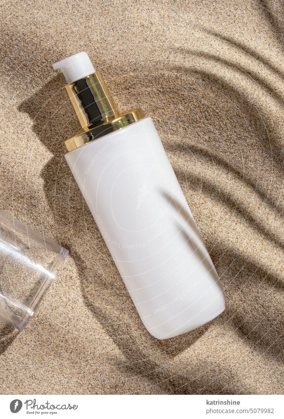 Blank white cream bottle on beige sand top view, palm leaf hard shadow. Cosmetic mockup blank cosmetics Package Natural skincare SPA Facial beauty routine Zen