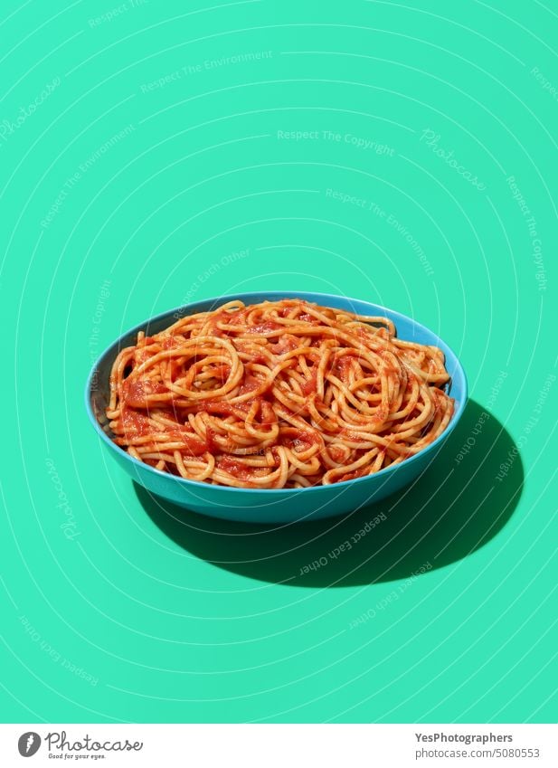 Spaghetti Pomodoro dish isolated on a green background above blue bowl bright carbs classic color copy space creative cuisine cut out delicious dinner eating