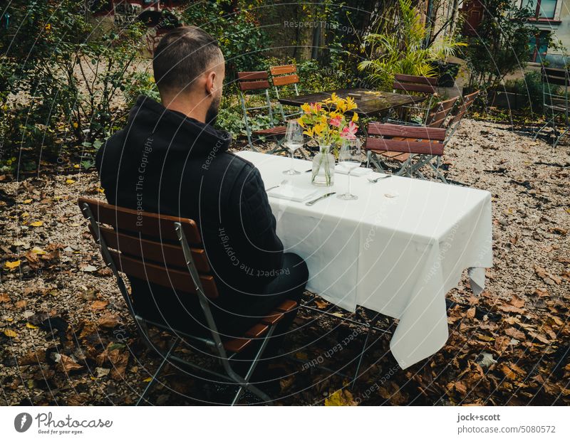 a man at the table covered with cut flowers laid table Man Feasts & Celebrations Decoration Napkin Bouquet Style Nature Cutlery Anticipation Human being Sit