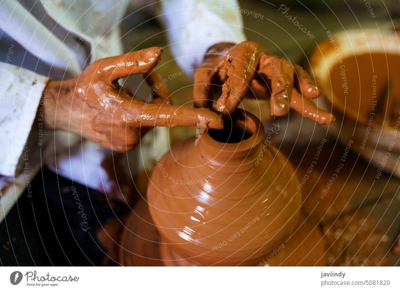 Craftsman moulding a piece of pottery on an Arab potter's wheel. craftsman clay potter wheel ceramic craftsmanship hand workshop handmade ansalusia spain person