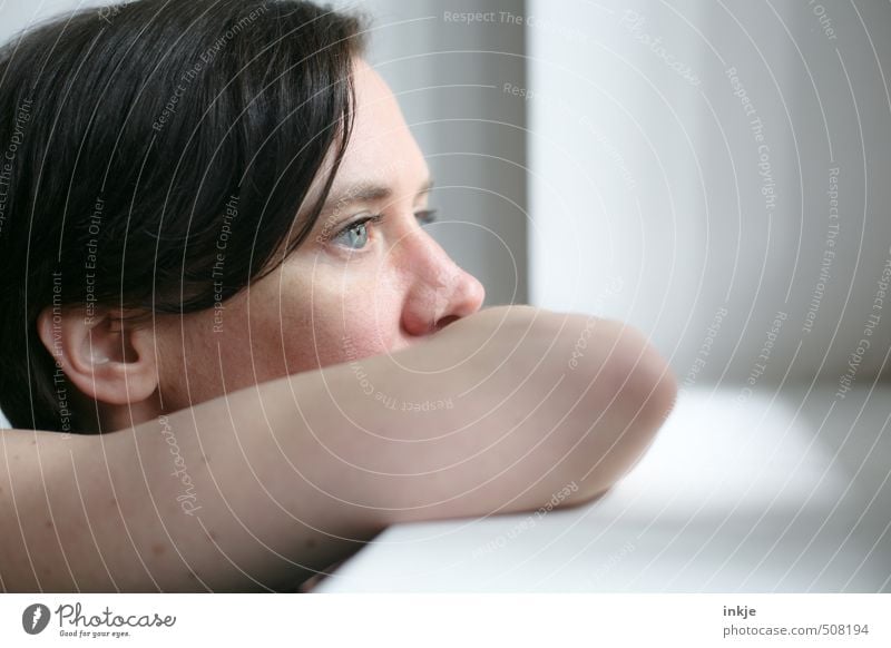 Woman looking out of the window Lifestyle Calm Adults Face 1 Human being 30 - 45 years Window Think Looking Dream Authentic Near Blue Black Emotions Moody