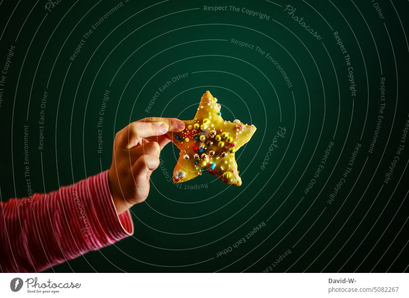 Child holds his home-baked Christmas cookie up to the camera at Christmas Decoration Christmas decoration Stars Christmas star bake cookies Christmas baking