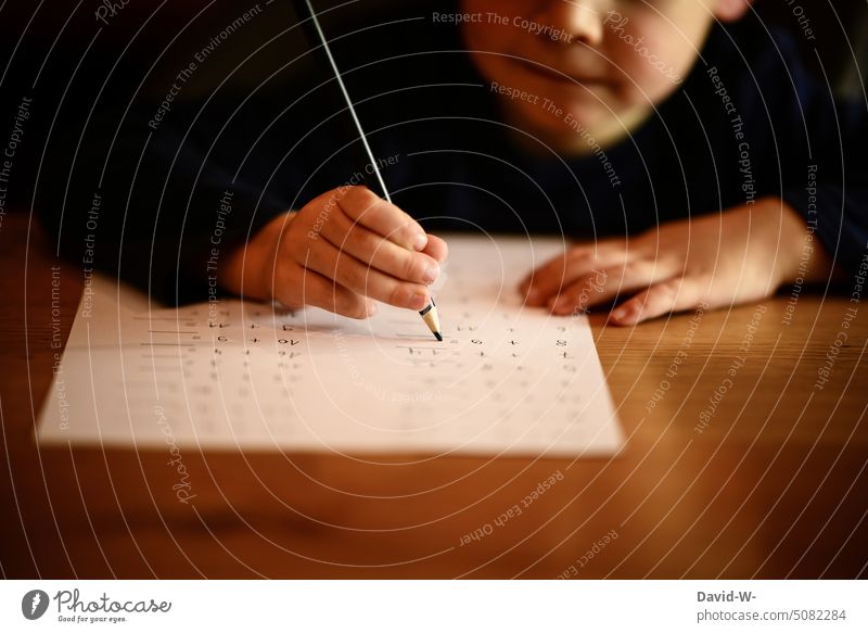 Child doing homework Homework Calculation Mathematics Study Practice pen Boy (child) School Education at home Piece of paper Joy fun Hand Desk Motive Diligent