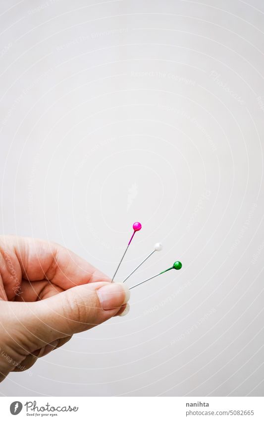 Conceptual image about choice with color pins against beige background minimal hand copy space negative green white pink sewing concept conceptual idea select