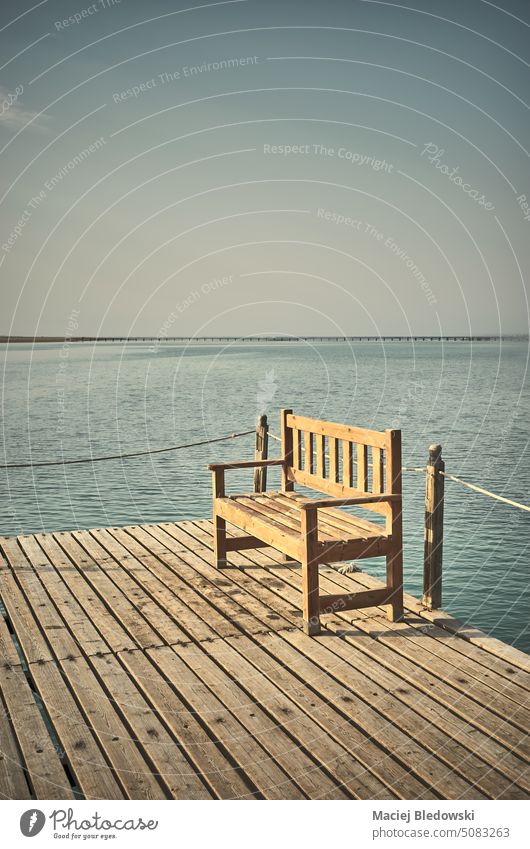 Wooden bench at a pier, retro style toning applied. relax wooden sea vacation water minimalist bridge summer travel ocean resort holiday toned sky nature island