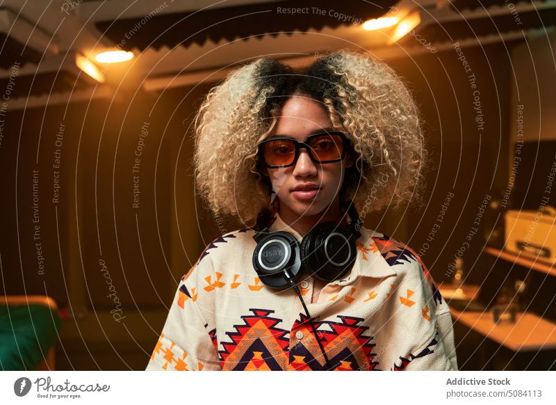 Ethnic woman with headphones on neck portrait musician studio enjoy entertain chill personality female acoustic song equipment stereo audio production melody