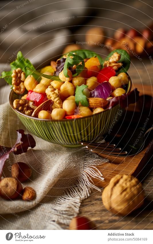 Healthy nuts and vegetables in bowl on table salad fork delicious food appetizing wooden walnut green linen organic tasty cutting board stainless yummy