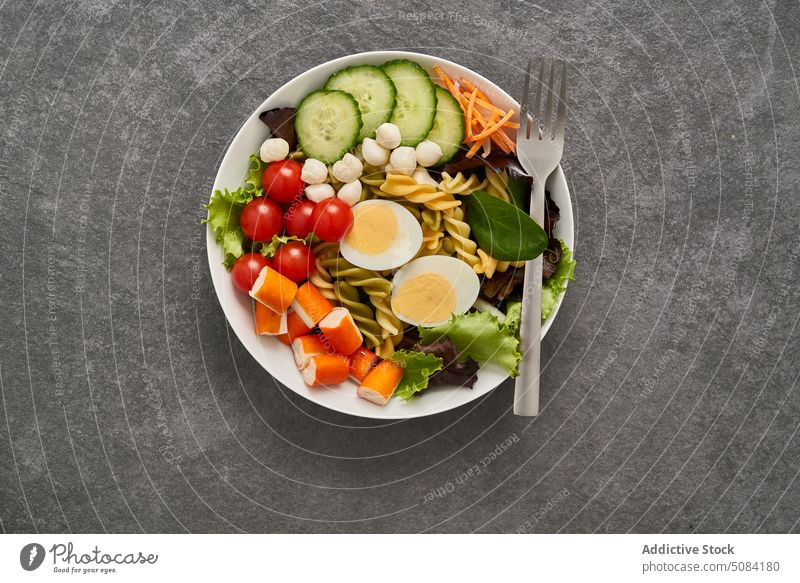 Bowl with salad assortments with fork bowl healthy food surimi vegetable pasta egg ingredient delicious cuisine meal dish tasty culinary fresh nutrition yummy