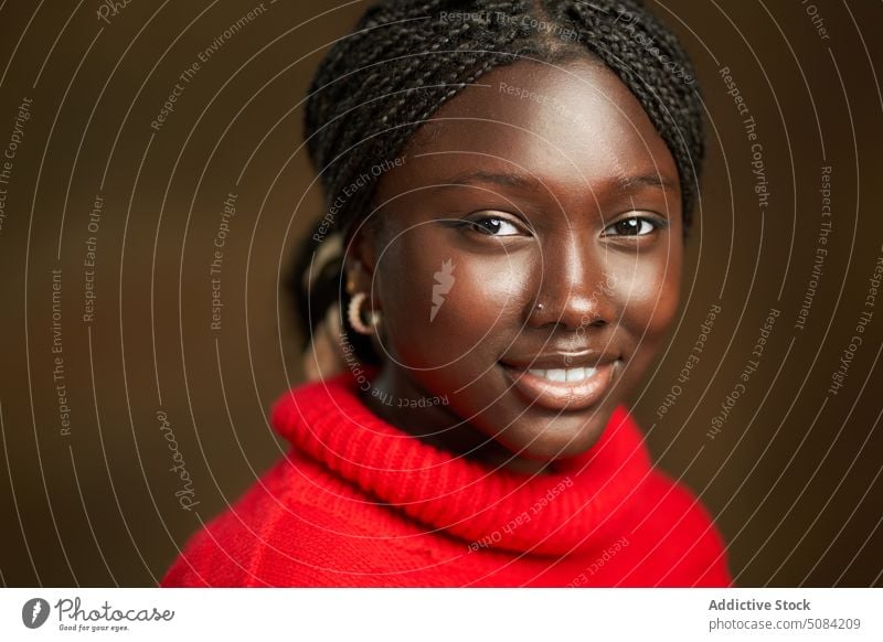 Calm happy black woman looking at camera model portrait smile afro braids appearance personality studio brown background human face calm female lady young