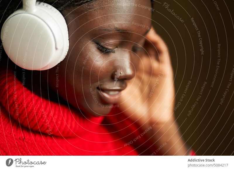 Smiling African American teenager in headphones woman model using listen music song happy having fun studio shot smile individuality gadget playlist positive