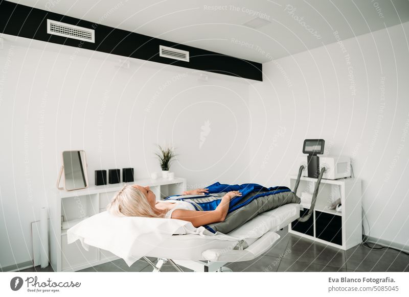 Relaxed woman enjoying in pressotherapy treatment at wellness center. caucasian clinic happy beautiful portrait alternative bed healthy healing masseuse