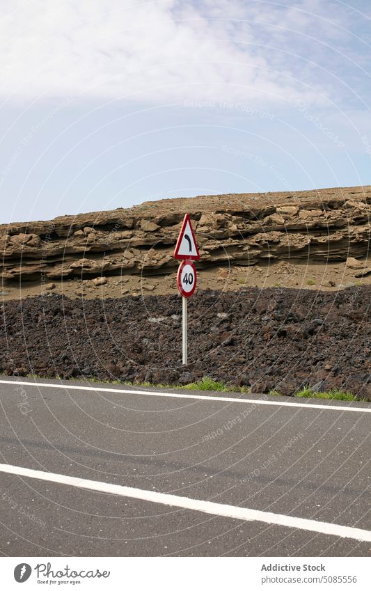 Asphalt road with signage in volcanic valley road sign highway route wild nature roadway desert trip scenery path daytime timanfaya national park lanzarote