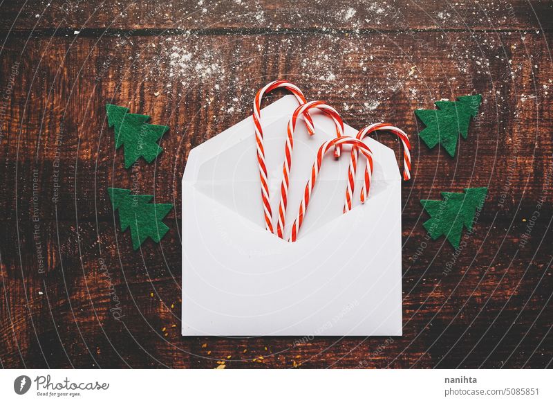 Christmas flatlay with a envelope full of candy canes against a rustic wooden background christmas mockup flat lay texture classic traditional tree snow paper