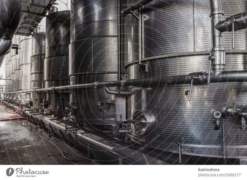 Steel tanks for wine fermentation at a modern winery. Large brewery silos for barley or beer row steel large storing fermeted blue sky stainless factory