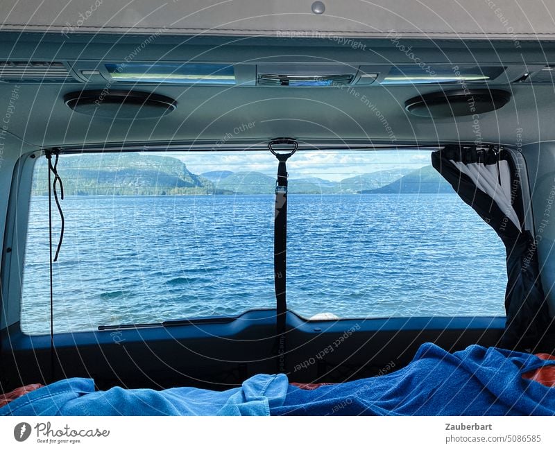 View from rear window of campervan on lake at vanlife or camping in Norway Camper Looking Rear Window Lake Bed Towels bulli Waves Morning Wake up Idyll