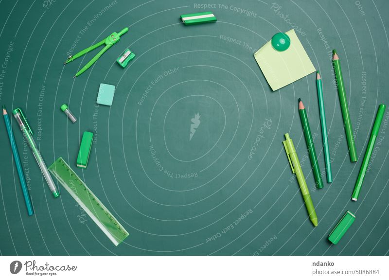 School supplies on empty green chalk board, top view. Back to school paper compasses ruler pencil shop stationery store study supermarket flat accessories