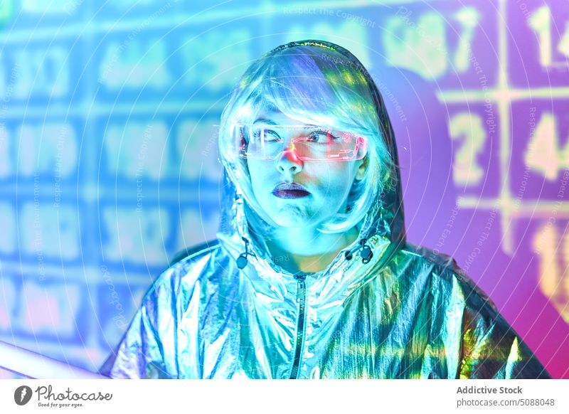 Futuristic woman with transparent goggles and virtual screen model innovation hi tech cyber portrait device illuminate neon future concentrate female red lips