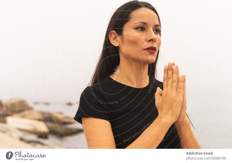Woman meditating with namaste hands woman practice yoga sea mist asana position exercise harmony focus sporty calm fit female tranquil pose gesture fog peaceful