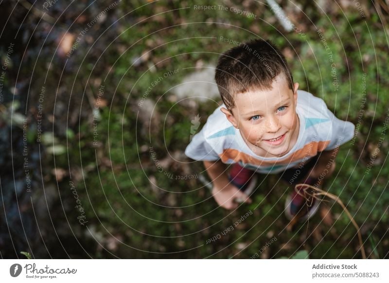 Happy boy looking up in countryside weekend explore curious smile glad autumn happy forest nature child childhood kid casual cheerful optimist daytime season