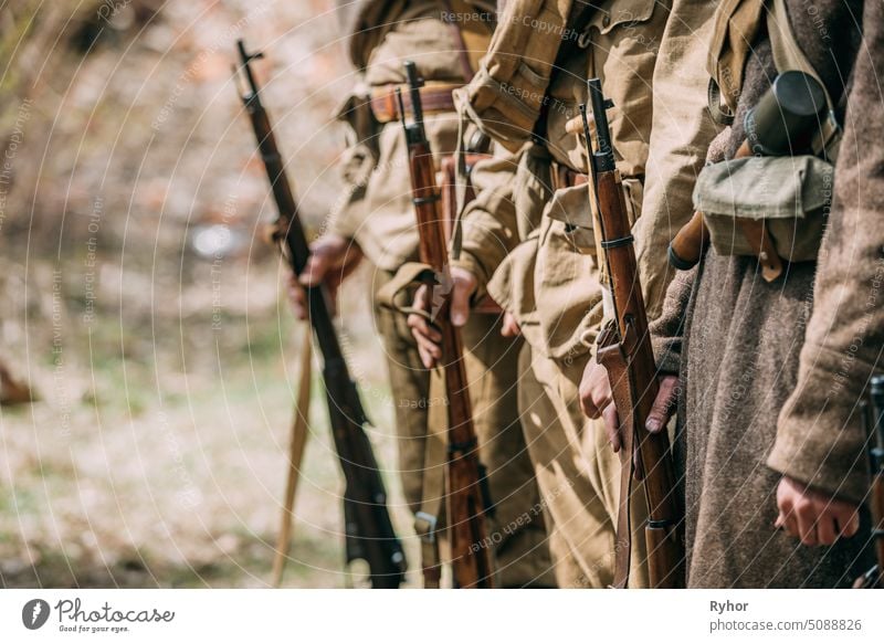Close Up Of Re-enactors Dressed As Soviet Infantry Soldiers Of World War II Holds Rifles Weapons In Hands. Russian Soldiers Standing Order war soviet rifleman