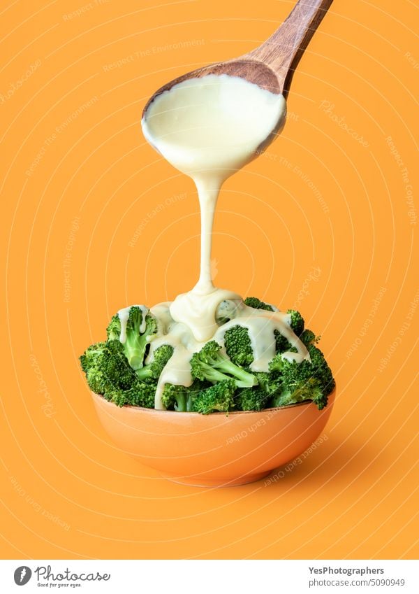 Brocolli with cheddar cheese dish. Pouring melted cheese over cooked broccoli. abundance background boiled bowl close-up color copy space cream cuisine cut out