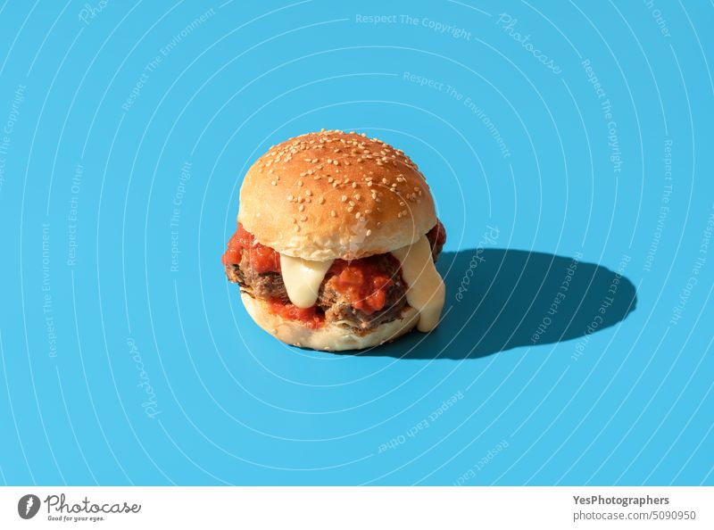 Burger with meatballs isolated on a blue background above beef bread bright bun burger calories cheddar cheese cheeseburger color copy space cuisine cut out